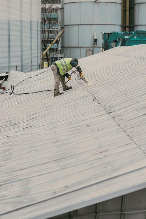 A roofer working on a metal roof